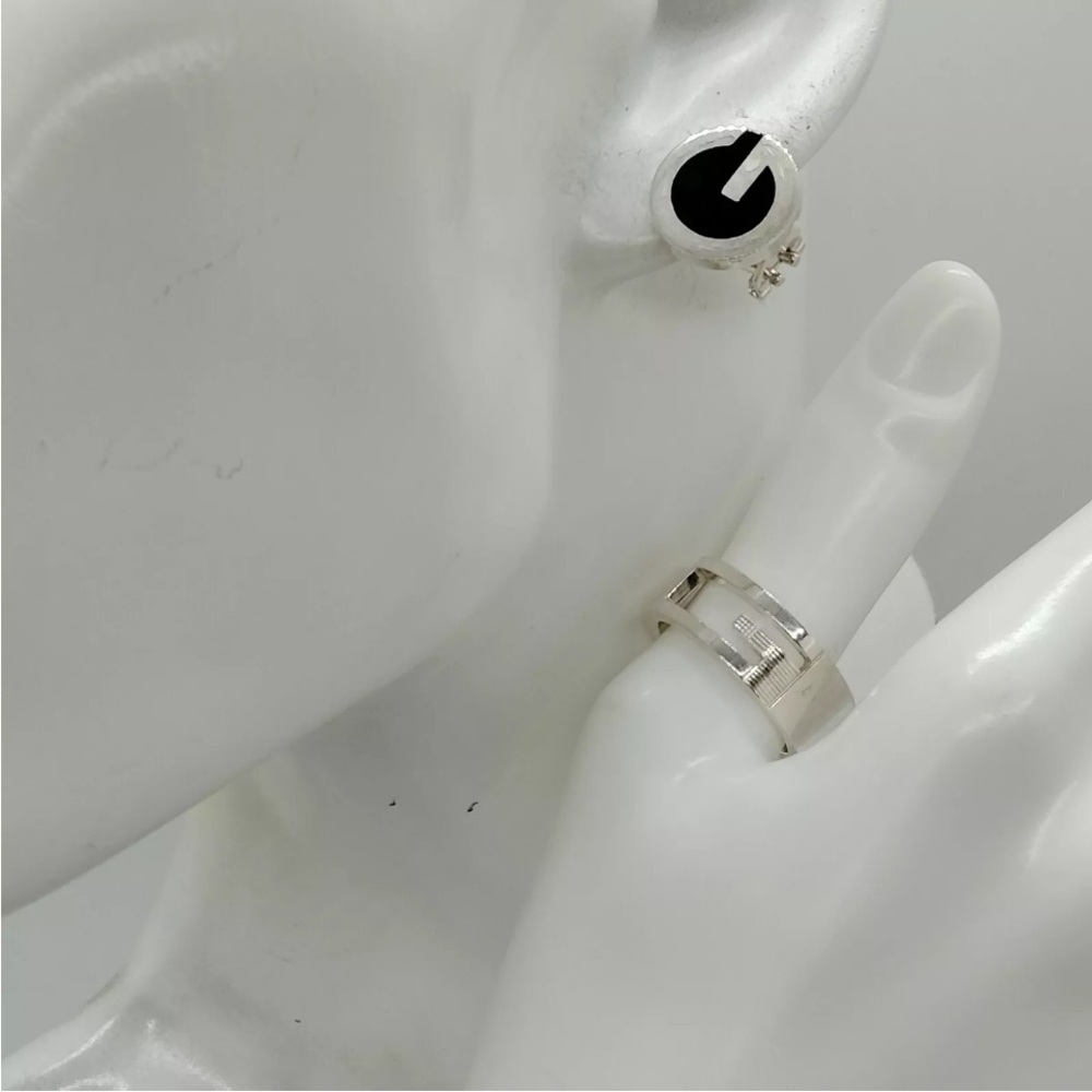 Gucci silver ring and pierced black and silver earrings.